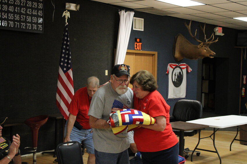 Rob Miller, of Warrenton, gets a hug from Marlene Walton as she presents the U.S. Army veteran his quilt.