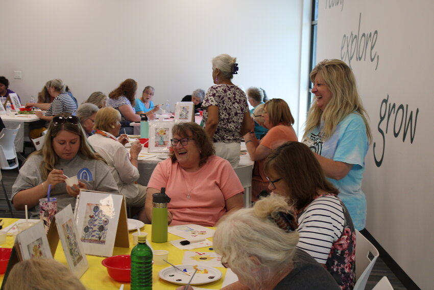 Linda Davis, in the pink shirt, has a laugh with Kerry Christian, the library's adult programmer, during the watercolor event.