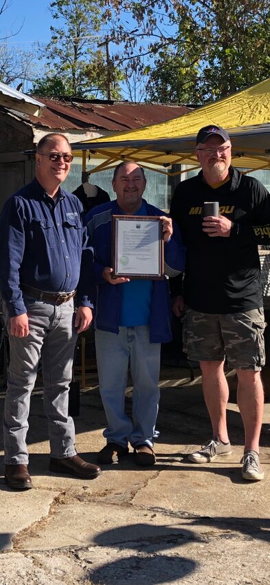 Truesdale Mayor Jerry Cannon, center, presents a proclamation to Paul, left, and Karl Brockfeld during an open house to celebrate the family-owned business' 140th anniversary.
