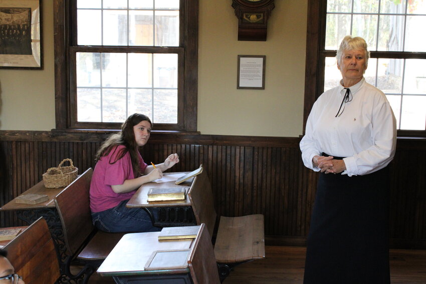 A Wright City Middle School student listens while Frau Jensen presents inside the one-room schoolhouse at the historic village in Innsbrook.