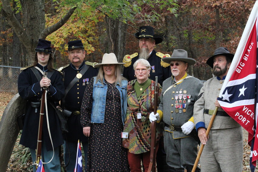 Kelley Wright and Linde Flanders, center, pose with some of the Civil War re-enactors who attended the ceremony, including Gary Dunakey, center in the blue hat, and Ray Cobb, far right holding the flag.