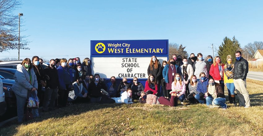 SCHOOL AWARD &mdash; Staff at Wright City West Elementary stand next to the marquee sign after announcing the school was recognized as a State School of Character, an honor received by only 56 of the 1,050 elementary schools in the state over the past five years.      Submitted photo.