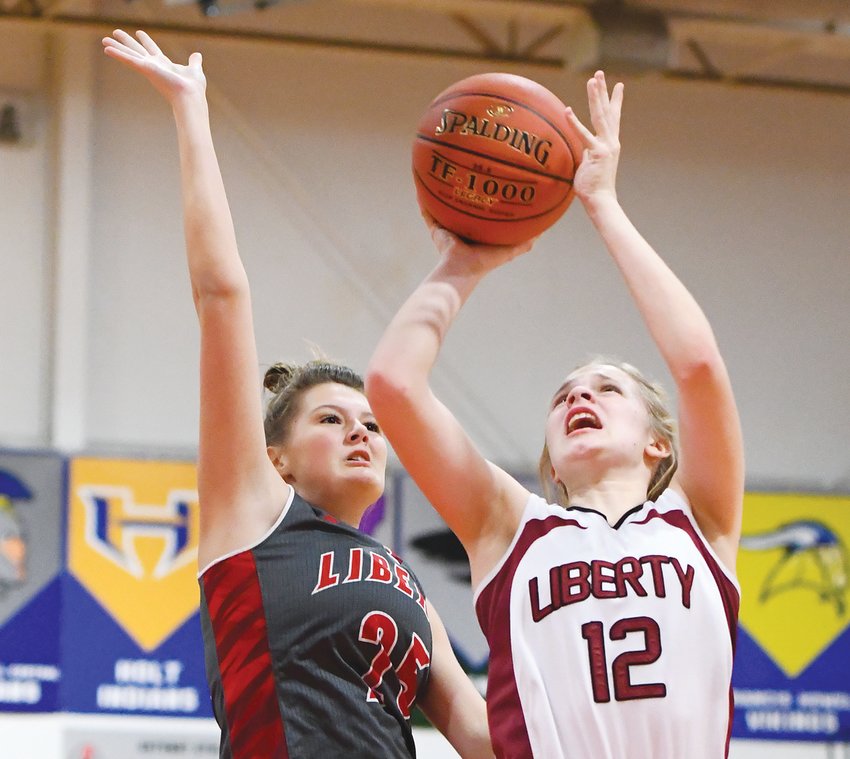 BATTLE DOWN LOW &mdash; Liberty Christian&rsquo;s Alli Meyer (12) goes up for a shot in Friday&rsquo;s game against Liberty. The Eagles capped off the Warrenton Winter Shootout by winning their final two games, including a 66-38 triumph in the consolation championship.	Bill Barrett photo.