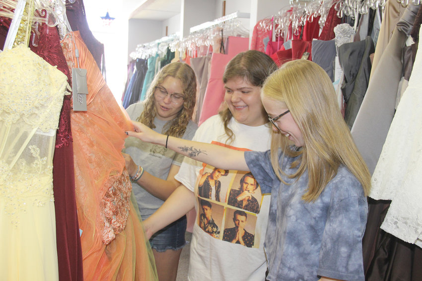 SHOPPING FOR PROM &mdash; Warrenton students Maggie Schipper, left, Savanah Miller, center, and Abby Mathison shop for prom dresses at Wedding Wishlist in Warrenton. The store is organizing prom events for Warrenton and Wright City high schoolers after their official school events were canceled. Montgomery students are also invited to attend.	Adam Rollins photo.