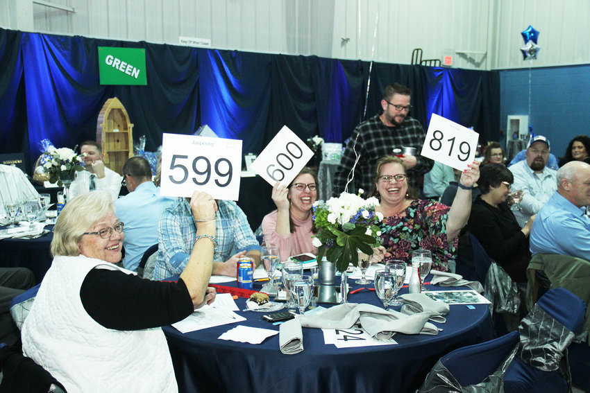 AUCTION RETURNS &mdash; Holy Rosary School will once again host an in-person dinner and auction Jan. 29 to raise funds in support of the school. Pictured here, bidders at the 2020 auction compete for an item.