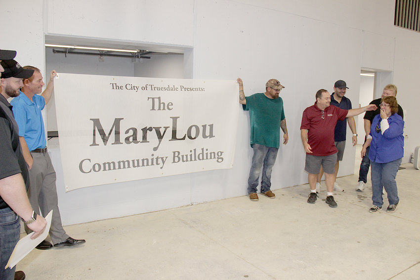 BUILDING DEDICATION &mdash; Truesdale City Administrator MaryLou Rainwater, far right, learns that aldermen have chosen to name the city&rsquo;s new community building in her honor. The building was dedicated during the opening of the Railroad Days festival Oct. 2.
