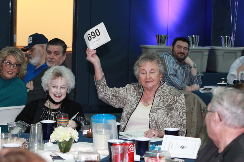 CONTESTED ITEM &mdash; Holy Rosary School supporter Mary Bracht competes for an auction item during live bidding at the school&rsquo;s annual dinner and community fundraiser last Saturday. More than 230 supporters attended the event.