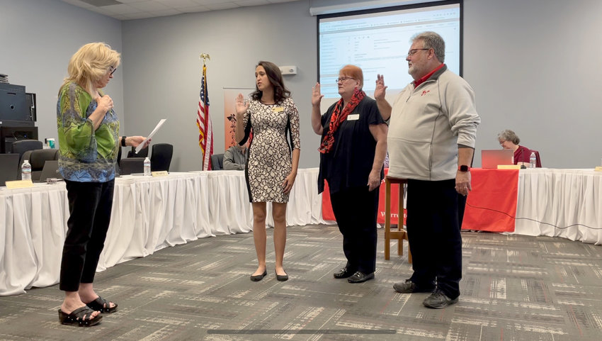 BOARD MEMBERS &mdash; Warren County R-III School Board members swear their oaths of office April 14 after being elected this month. Taking the oath, from left, are incumbents Sarah Janes and Ginger Schenck, and new member Rich Barton.