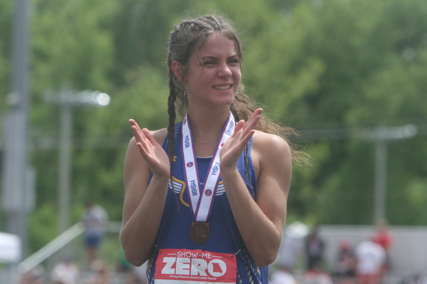 Wright City sophomore Elizabeth Riggs claps while standing on the podium at the Class 3 state track championship meet on May 28 at Jefferson City. Riggs placed third in the 300-meter hurdles in 47.27 seconds for her first all-state medal.