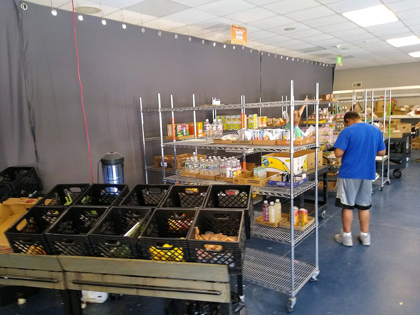 Workers at the Agape food pantry in Warrenton stock and organize shelves where clients can pick out grocery items that they need.