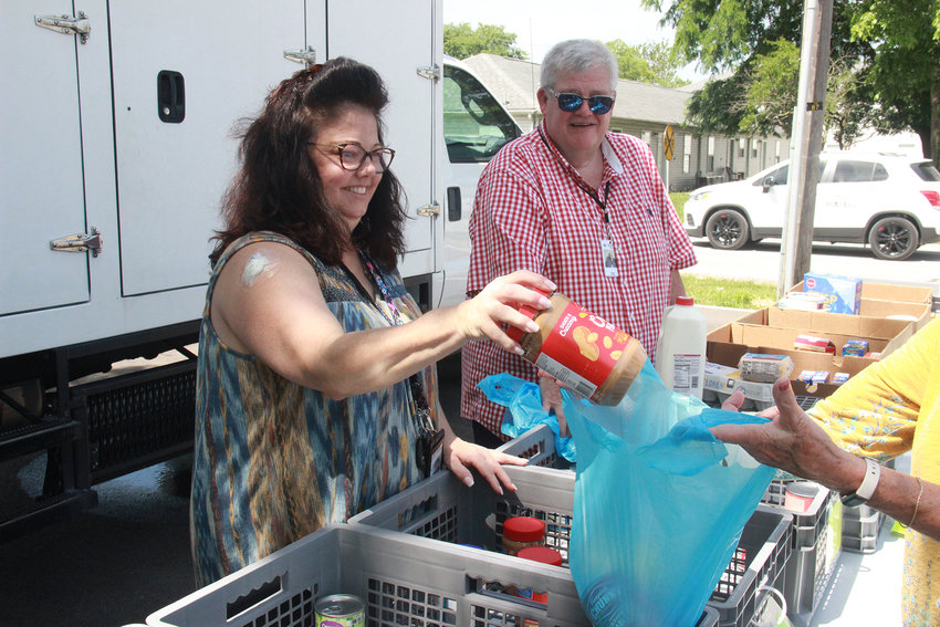 MOBILE PANTRY &mdash; Sts. Joachim and Ann Care Service staff member Michelle Ritter and volunteer Thom Johnson help distribute food at their mobile food pantry stop in Bruer Park on June 16.