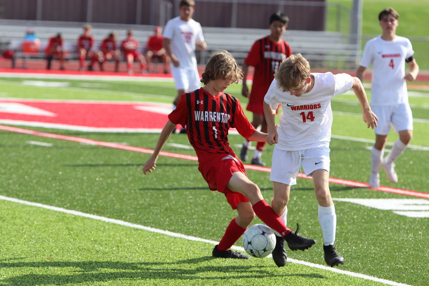 Evan Donovan (left) battles for possession of the ball during the Jamboree last month. Donovan scored one of Warrenton's two goals in the Warriors' win last week.