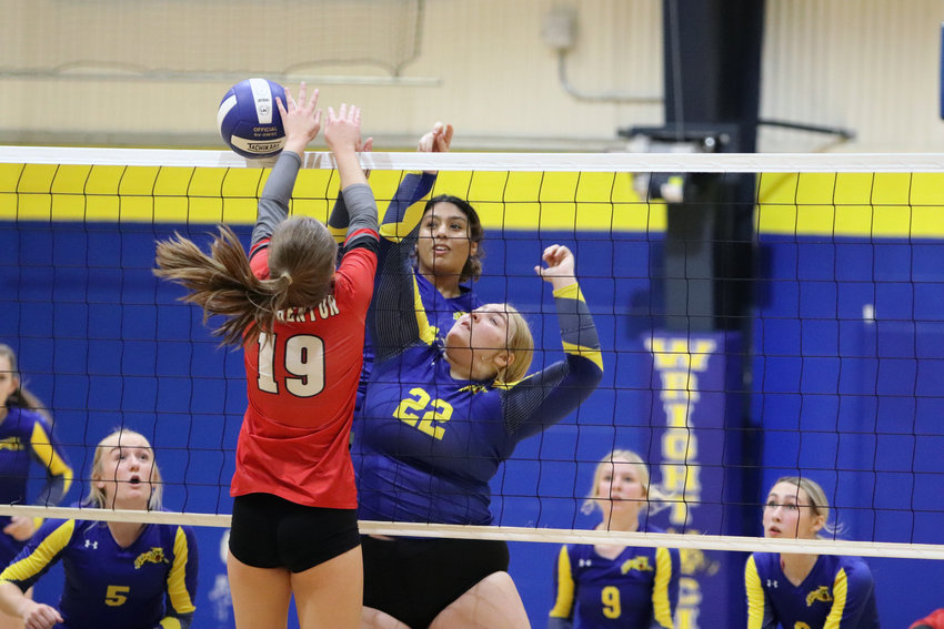 Alexei Gatewood (22) attempts to push the ball over the net as Emily Likes (19) tries to block the shot attempt.