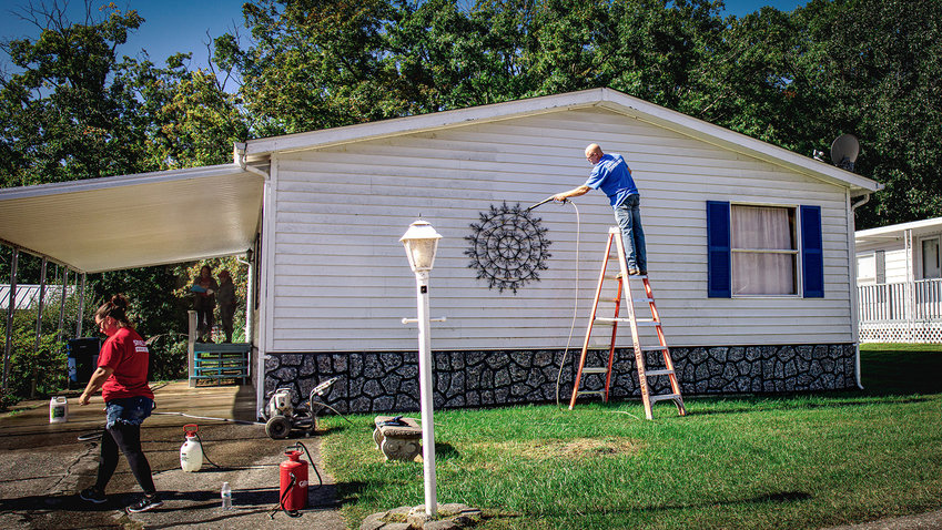 Volunteers with Faith Christian Family Church clean the exterior of a home in Lakeview Estates as part of the church's Serve Day event in October.