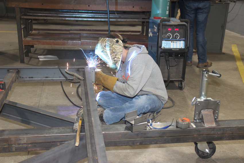TRADE SKILLS &mdash; Warrenton High School senior Ben Flake uses an arc welder to attach post holders to the frame of a utility trailer. Students in the school&rsquo;s ag construction class are learning trade skills in part by building market-quality trailers that will be sold and used to pay for future class projects.