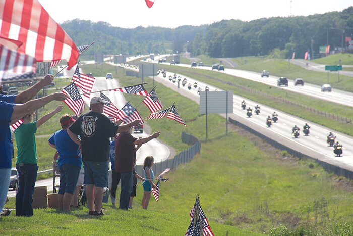 A group of supporters waves flags and cheers on the Run for the Wall riders as they passed by the Warren County Veteran's Memorial in Warrenton on May 22.