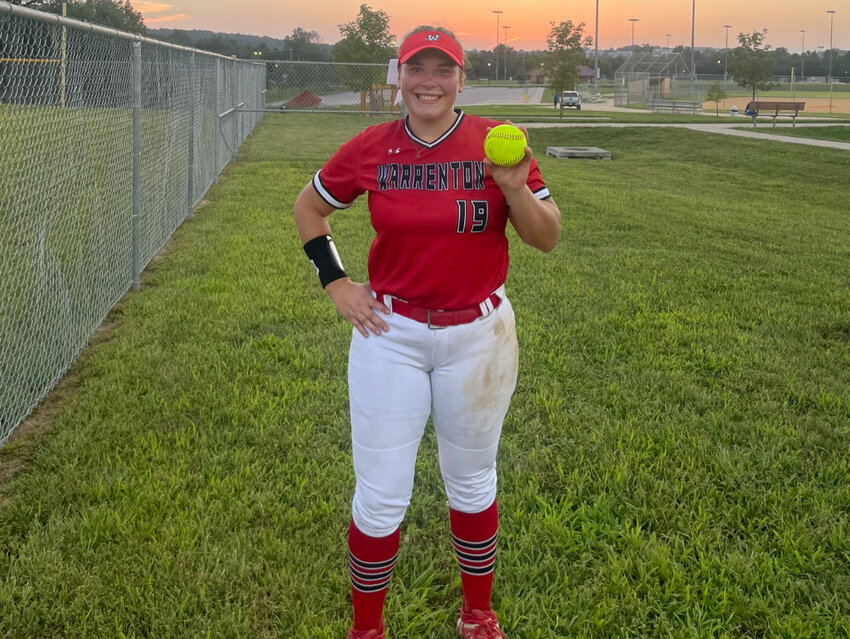 Kylie Witthaus holds the ball she used to throw a perfect game against Perryville as the Warriors won 15-0.