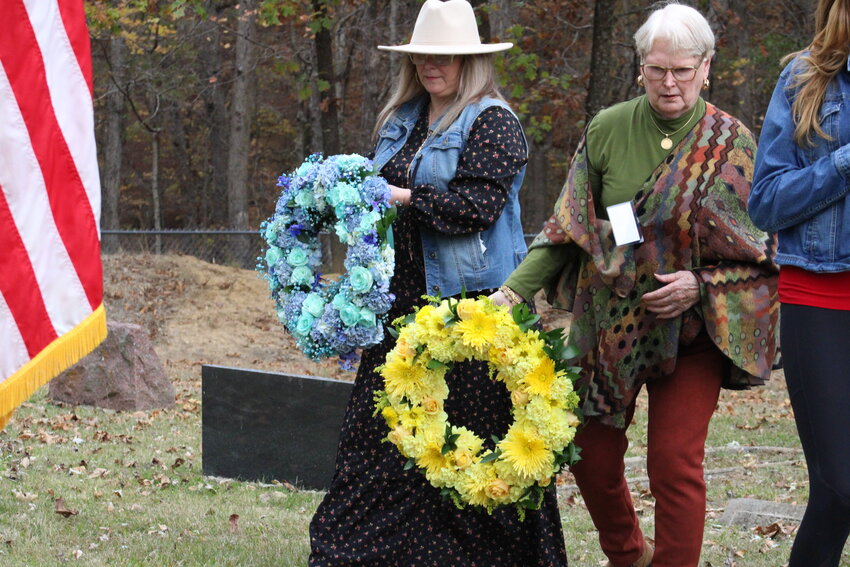 Kelley Wright and Linde Flanders lay wreaths on the newly-dedicated stones marking the mass grave of Union and Confederate soldiers buried in the cemetery at Harmonie Church.