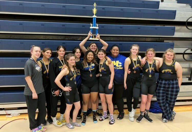 Caelyn Hanff raises the championship trophy after the Wright City girls wrestling team won the John Burroughs Invite team title for the second consecutive year.