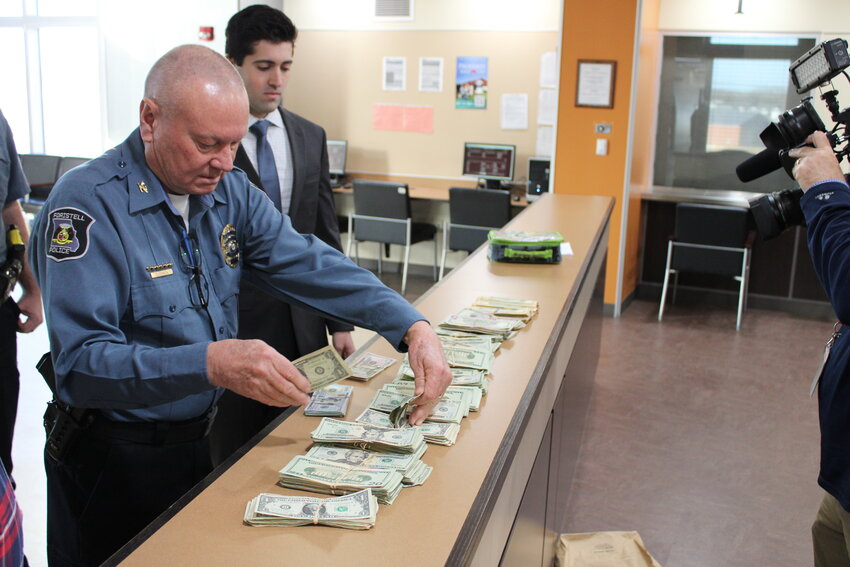 Foristell Police Chief Douglas Johnson lays out $31,540 in money seized during a traffic stop in 2017. Johnson brought the money to the Warren County Administration Building on Feb. 13 to turn it over to Warren County Treasurer Jeff Hoelscher so it could be distributed to local school districts. The money will officially be distributed in October.