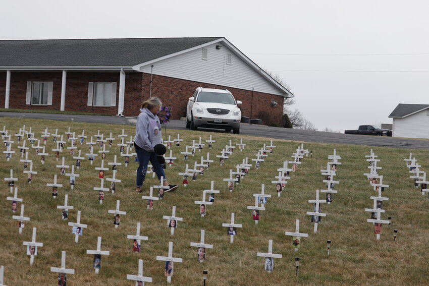 Sabrina Wipfler walks through a field of 307 crosses in front of Pittman Funeral Home along Highway 47 on March 5 in Warrenton.