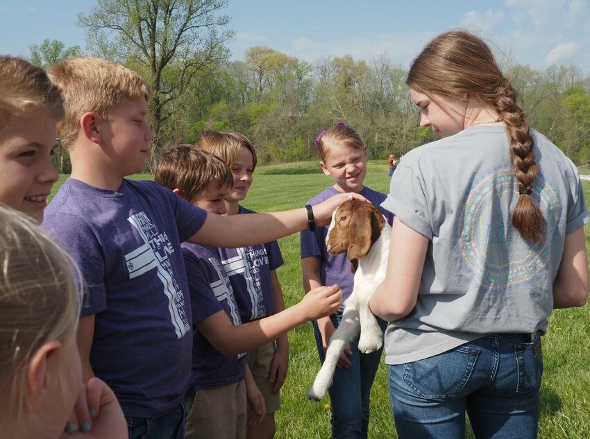 Savanna Miller, right, a Warrenton High School FFA member, introduced her Boer goat to the students from Holy Rosary. Other stations included electricity, soils, trees and wildlife, rocks and minerals, pollinators and farm safety. Lunch was provided by the Warren County Pork Producers.