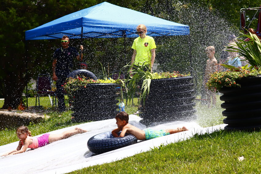 Amelia Mese, 5, left, and Ryan Hammers, 5, dive down the slip n slide at the event. Mese described the event as 