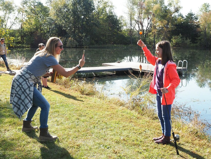 Warrior Ridge Elementary teacher Brand Gagliano, left, takes a snapshot of fourth-grade student Harper Brozek after catching another small fish during the Puetz Farm tour sponsored by the Warren County Soil & Water Conservation District. The Puetz Farm location is the only one that includes fishing as one of its stops. Other stations teach about soil health, trees and wildlife, farm safety, farm animals and crops, electricity, and rocks and minerals. The tour, held Tuesday and Thursday, Oct. 8th and 10th, also hosted students from Rebecca and Daniel Boone Elementary Schools.