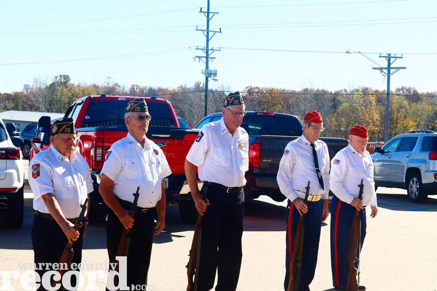 Members of the VFW Post 2180 and the color guard from the Nov. 11 Veterans Day service at the Warrenton Elks Lodge stand at attention following the 21-gun salute that concluded the day&rsquo;s memorial as taps was played outside the Elks Lodge.