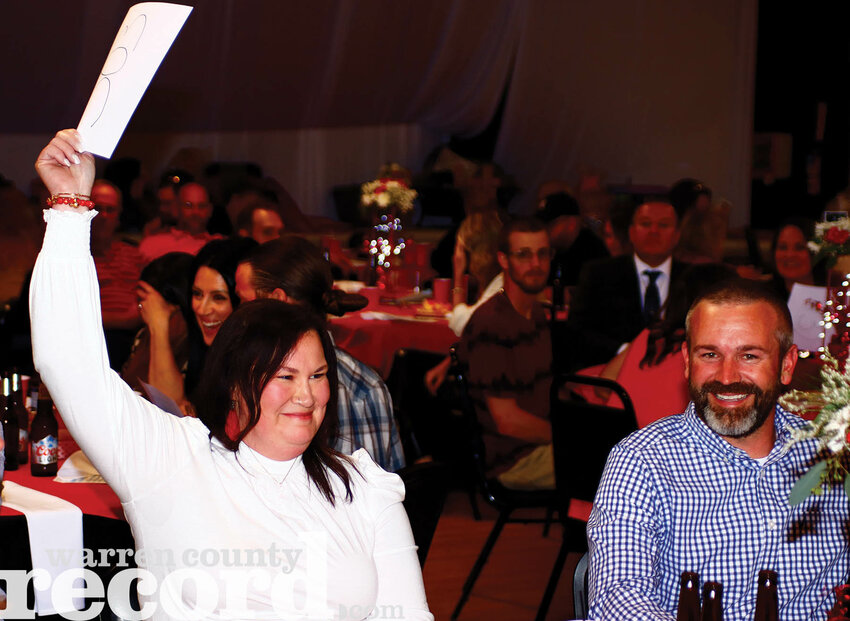 Malerie O'Brien raises her bid placard to purchase an ultimate outdoor adventure pack donated by Warrior Fans for $1,100. She continued to bid on the item against other suitors saying "it's a fundraiser and I want it."
