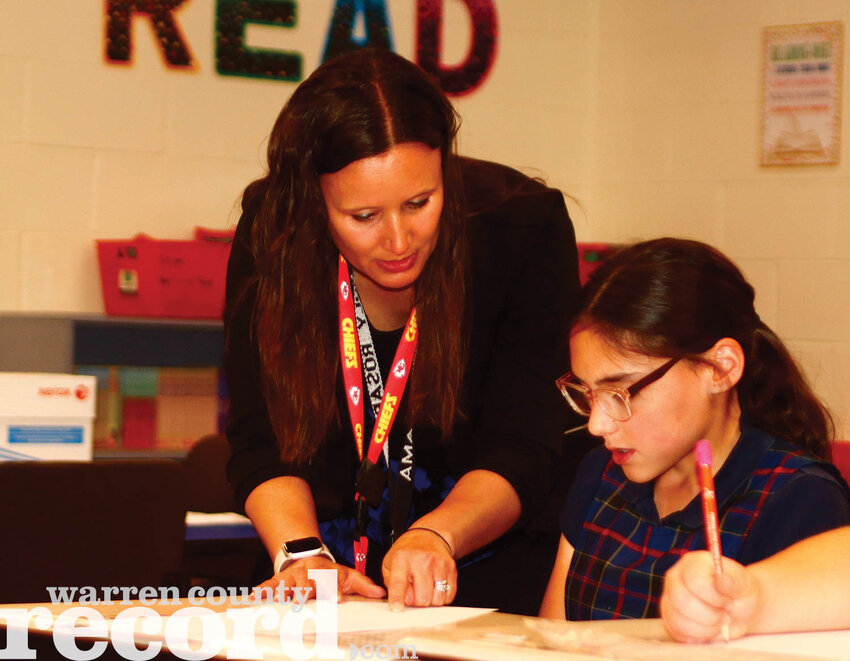 Newly minted Holy Rosary Catholic School Principal Amanda Muckerman helps the students in her fourth grade class with a lesson on units and measurements. Muckerman is currently working as both a teacher and as principal but will step away from the classroom and start as the principal full time at the start of the next school year.