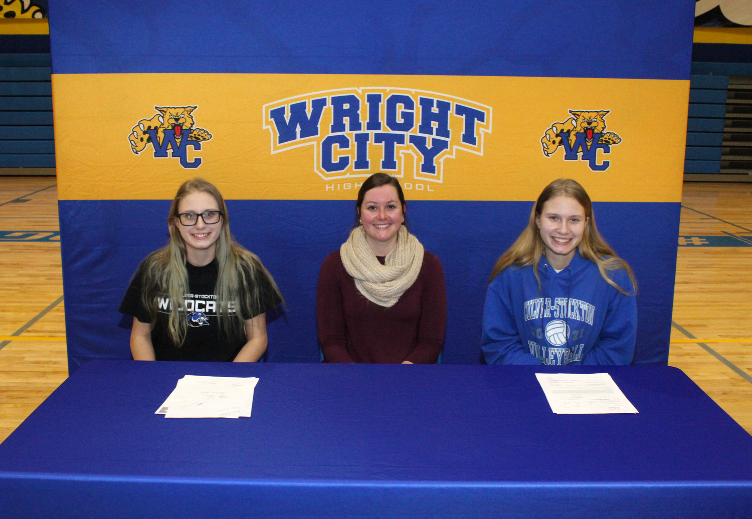 STILL WILDCATS — Wright City volleyball players Ashleigh Williams, left, and Emily Williams, far right, signed their letters of intent to play volleyball for Culver-Stockton College on Feb. 3, joined by a small group of family and supporters. Also pictured is Wright City Head Coach Christine Klem.        Derrick Forsythe photo.