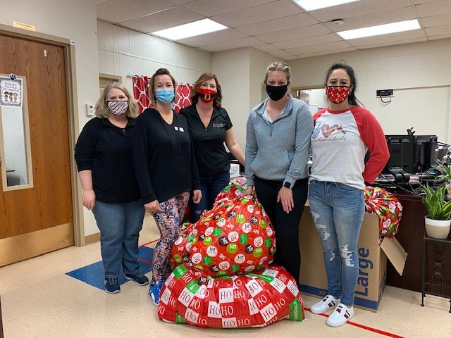 BRINGING JOY -- Main Street Real Estate donated gifts for about 160 children in Warren County R-III schools this month. Seen here at Rebecca Boone Elementary, from left, are Main Street staff member Maggie Hase, owners Stacey Blondin and Samantha Richardson, and staff members Samantha Walch and Donna Hency.      Submitted photo.