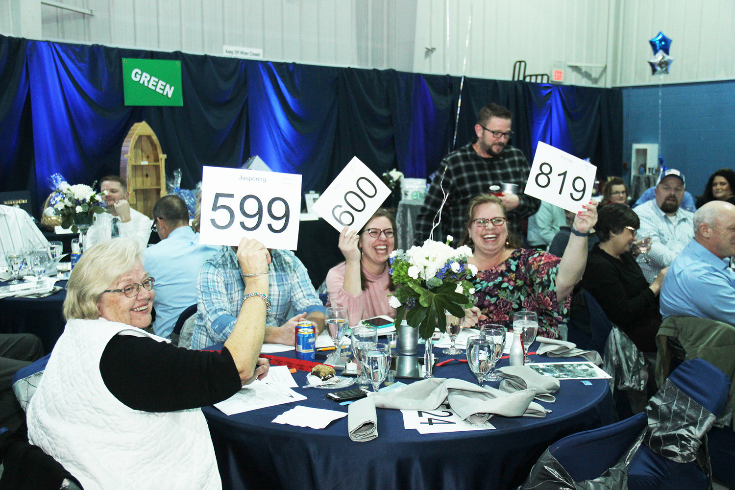 AUCTION RETURNS — Holy Rosary School will once again host an in-person dinner and auction Jan. 29 to raise funds in support of the school. Pictured here, bidders at the 2020 auction compete for an item.