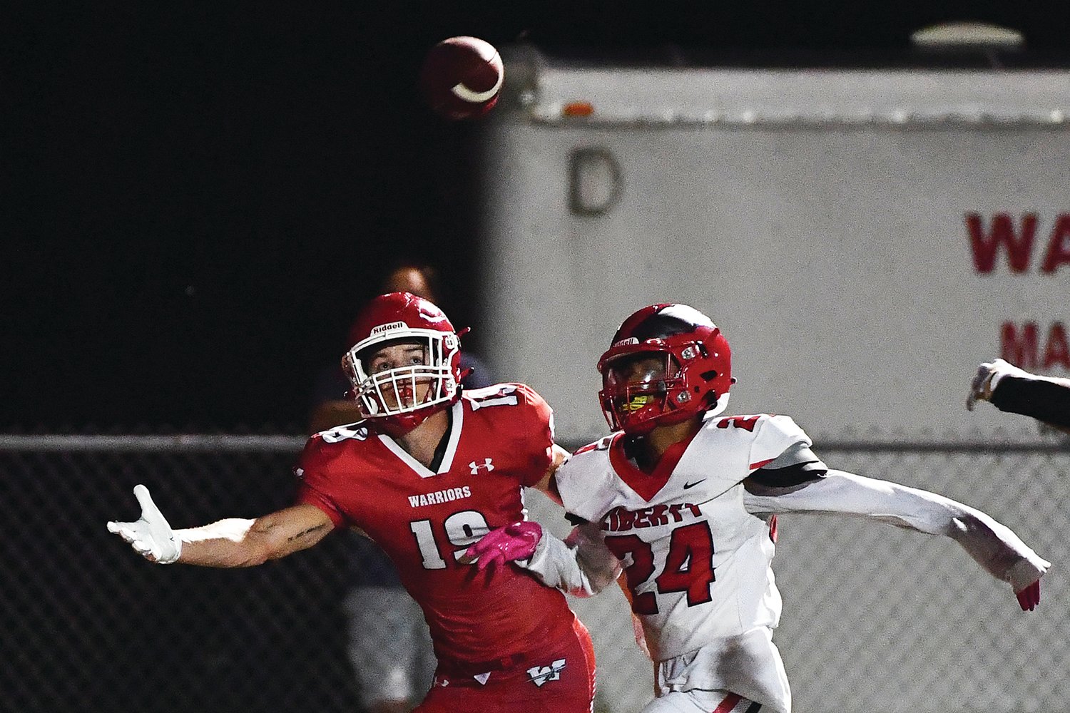 SIDELINE BATTLE — Warrenton’s Joseph Evans reaches for a pass in Friday’s season opener against Liberty. The Warriors fell 28-14 in the debut for head coach Jason Koper.