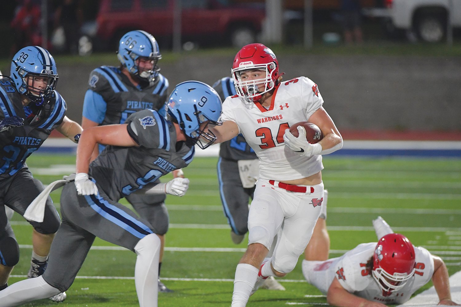 MOVING THE CHAINS — Warrenton running back Joe Goldsmith (34)  gains some yardage in Friday’s road game at St. Charles. Goldsmith rushed for a team-best 97 yards on 13 carries in the Warriors’ 42-8 victory.