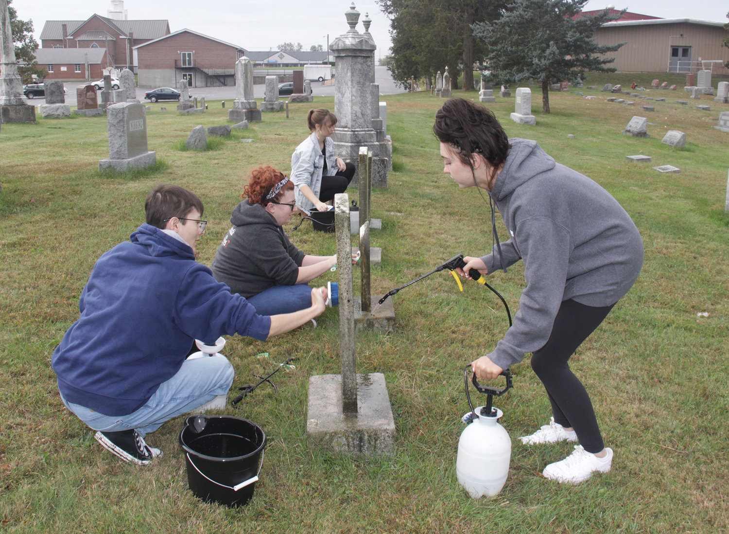 CARING FOR THE FORGOTTEN — Members of the Wright City High School Student Council helped clean some of the oldest grave stones in the Wright City Cemetery on Saturday, Oct. 23. Many of the graves no longer have living families to care for them. Pictured, from left to right, are Jeronimo Lesmes, faculty sponsor Whitney Schuenemeyer, Payton Mosbey, and Lily Lamb. Other students came and went throughout the day.