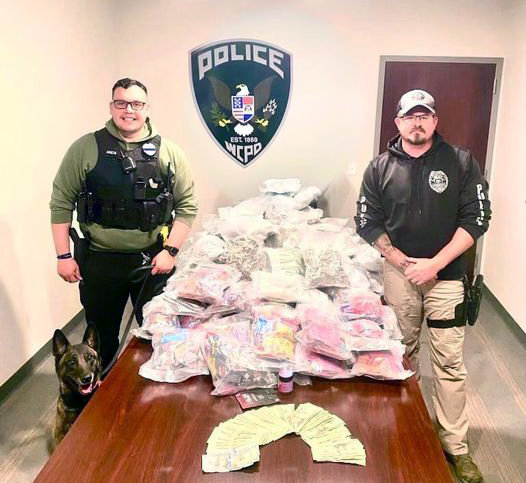 DRUG BUST — Pictured, from left, Wright City K-9 Athena, Officer Malta, and Detective Sparks display over 120 pounds of marijuana and mushrooms, and almost $3,000 in cash, that was seized in an arrest on March 22.