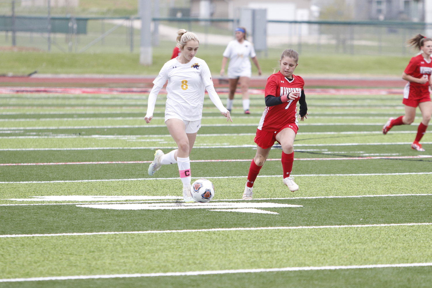 Alex Sutter (left) attempts to move the ball towards the goal in the first half of last week’s game as Ashlynn Reeves trails the play.