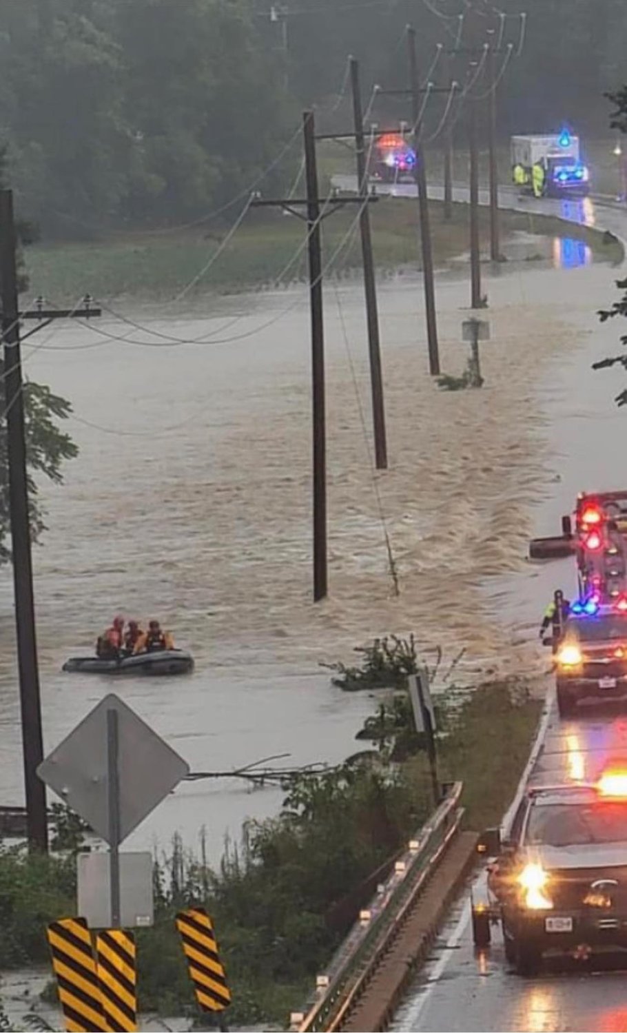Firefighters maneuver a rescue boat through rapid floodwater that has overtaken Highway J north of Wright City on Tuesday, July 26.
