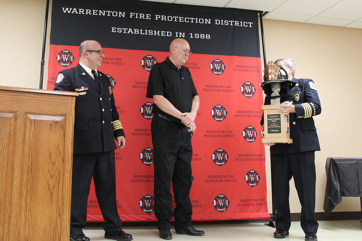 50-YEAR FIREFIGHTER – Volunteer firefighter Frank Dieckman, center, receives a custom-crafted award for 50 years of service with Warrenton Fire Protection District. Presenting the award are Chief Anthony Hayeslip and Assistant Chief Keith Smith.