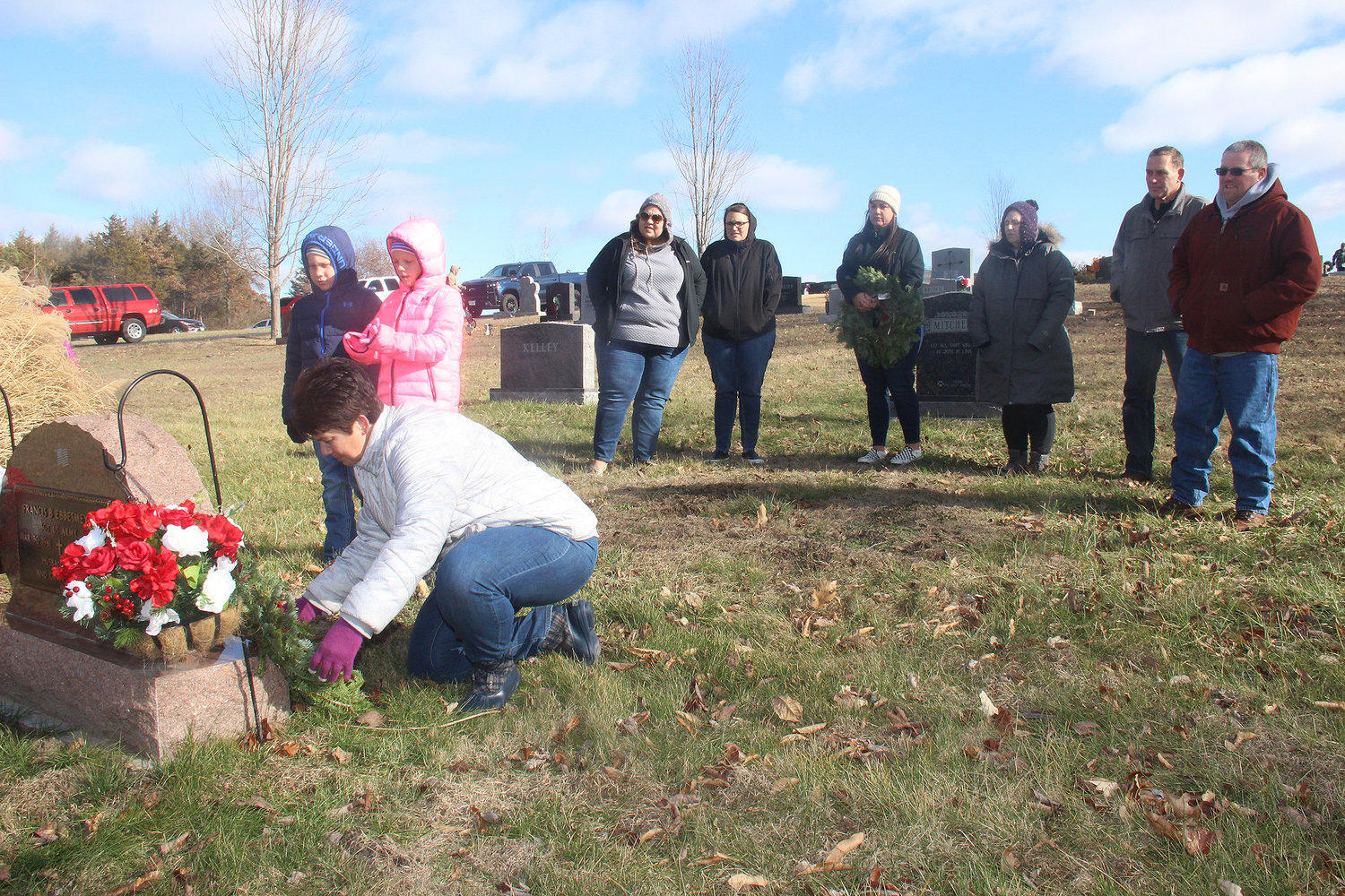GENERATIONS REMEMBER — The family of deceased veteran Frank Ebbesmeyer lay a wreath at his grave in the Holy Rosary Cemetery during the Wreaths Across America program on Dec. 17. Wreaths were laid at the graves of more than 500 local veterans to honor their service and teach new generations about their importance.