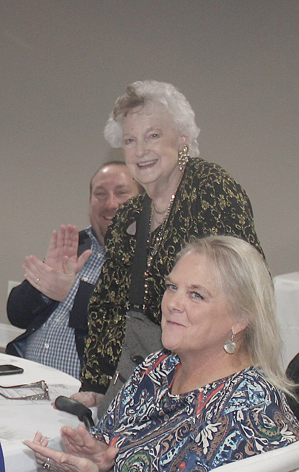 LONGTIME MEMBER — Alouise Marschel, standing, receives applause and cheers as she is recognized as the Warrenton Chamber’s longest active member during the group’s 100th anniversary banquet.