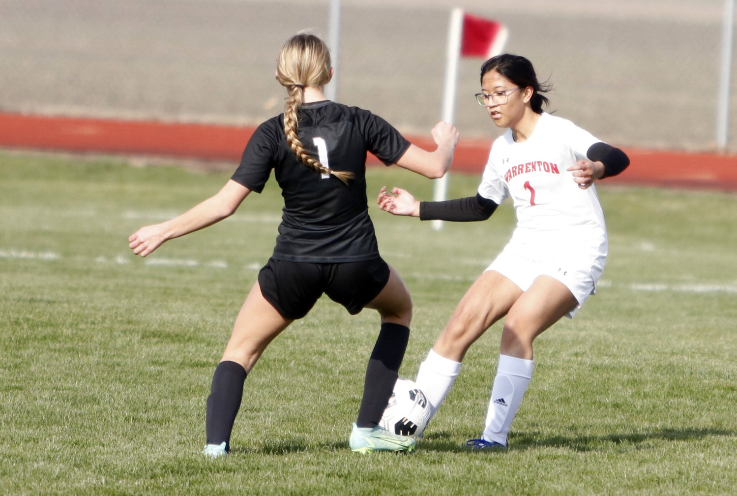 Warrenton senior Princess Cullom kicks the ball as she is challenged by an Orchard Farm defender during Tuesday's game.
