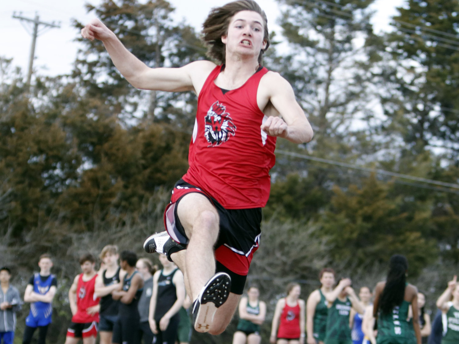 Warrenton's Colton Brosenne leaps in the air during the long jump competition.