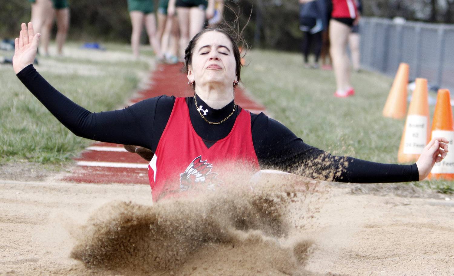 Kiera Daniel lands in the sand pit during the long jump competition.