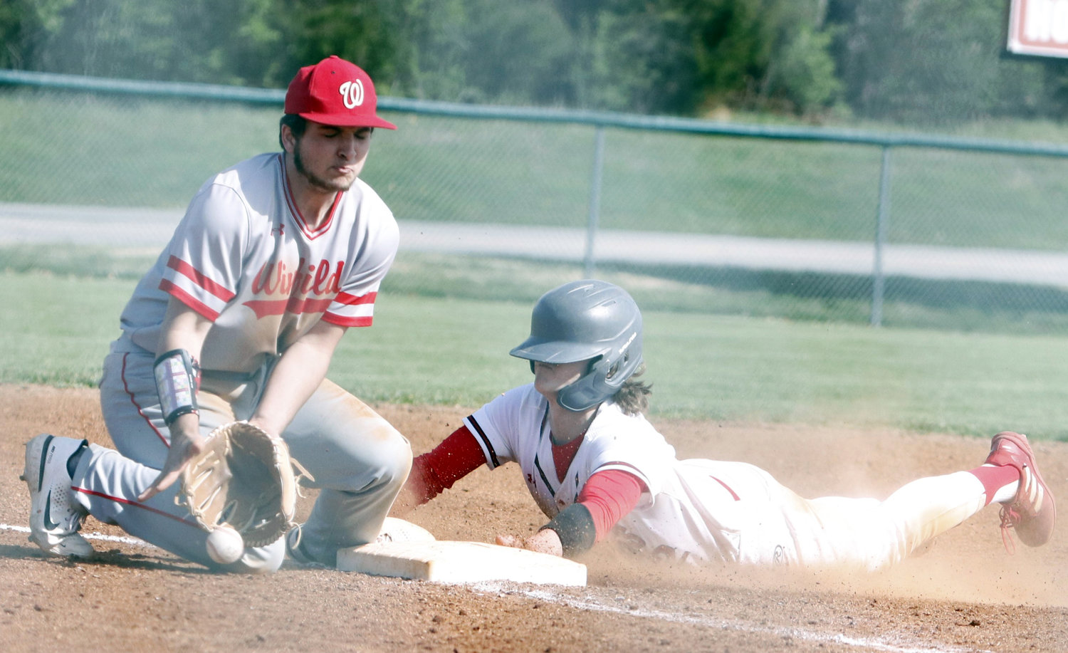 Warrenton senior Kannon Hibbs (right) dives safely into third base during the fifth inning of Warrenton’s 8-1 win over Winfield Friday.  Hibbs was ruled safe on the play and scored later in the inning.