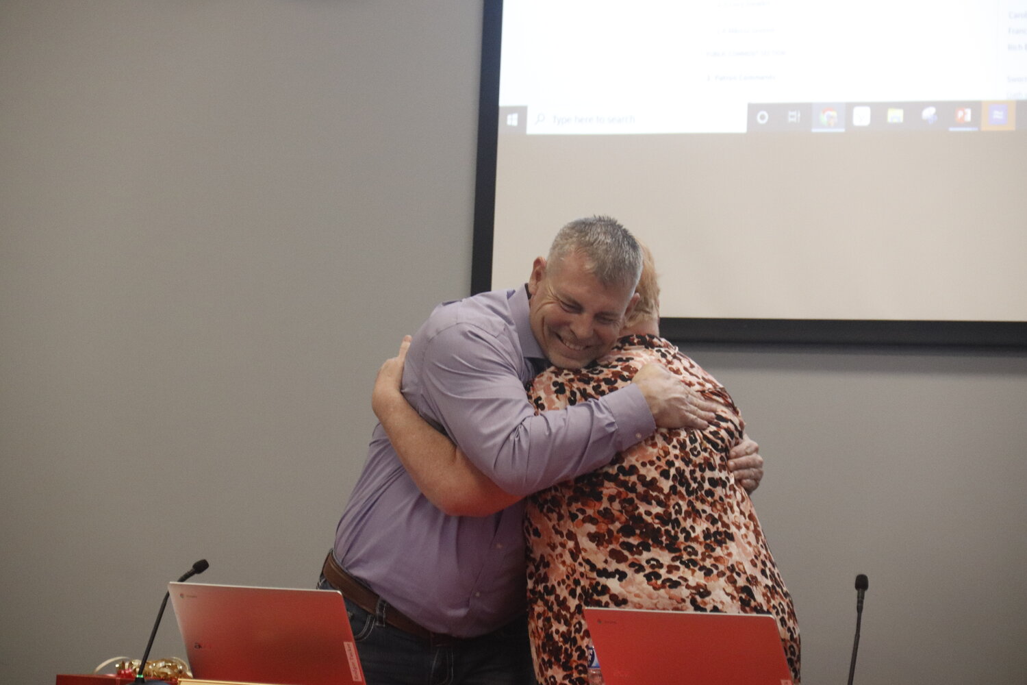 Former Warren County R-III school board member Rodger Tucker (left) hugs current board member Ginger Schenck during last week’s regular board meeting. Tucker decided not to run for reelection after serving on the school board for six years.