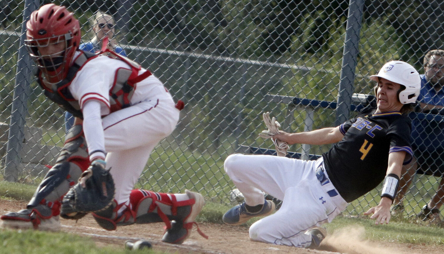 Jake Mitts (right) slides safely into home plate during last week's game.