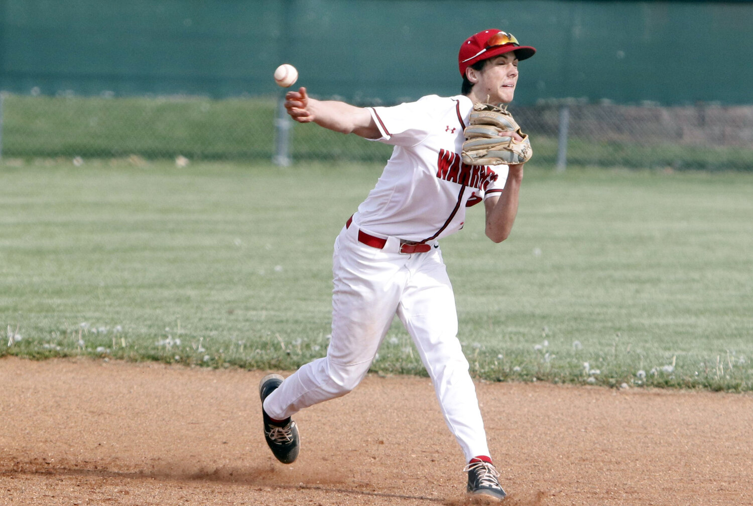 Warrenton shortstop Collin Disilvister throws the ball to first base to record an out.